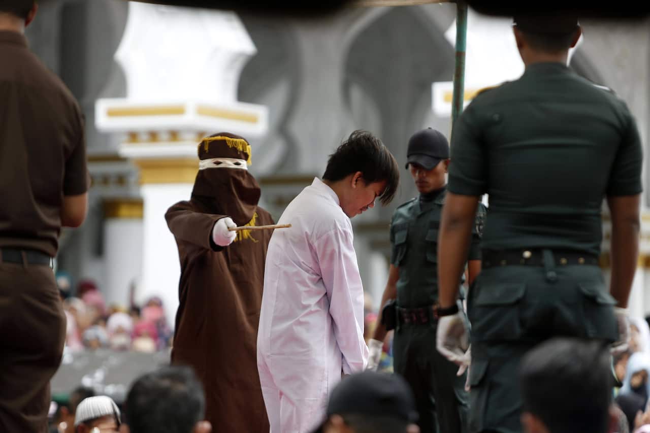 A man is whipped in front of the public as punishment for being in a same-sex relationship in Banda Aceh, Indonesia, 23 May 2017. 