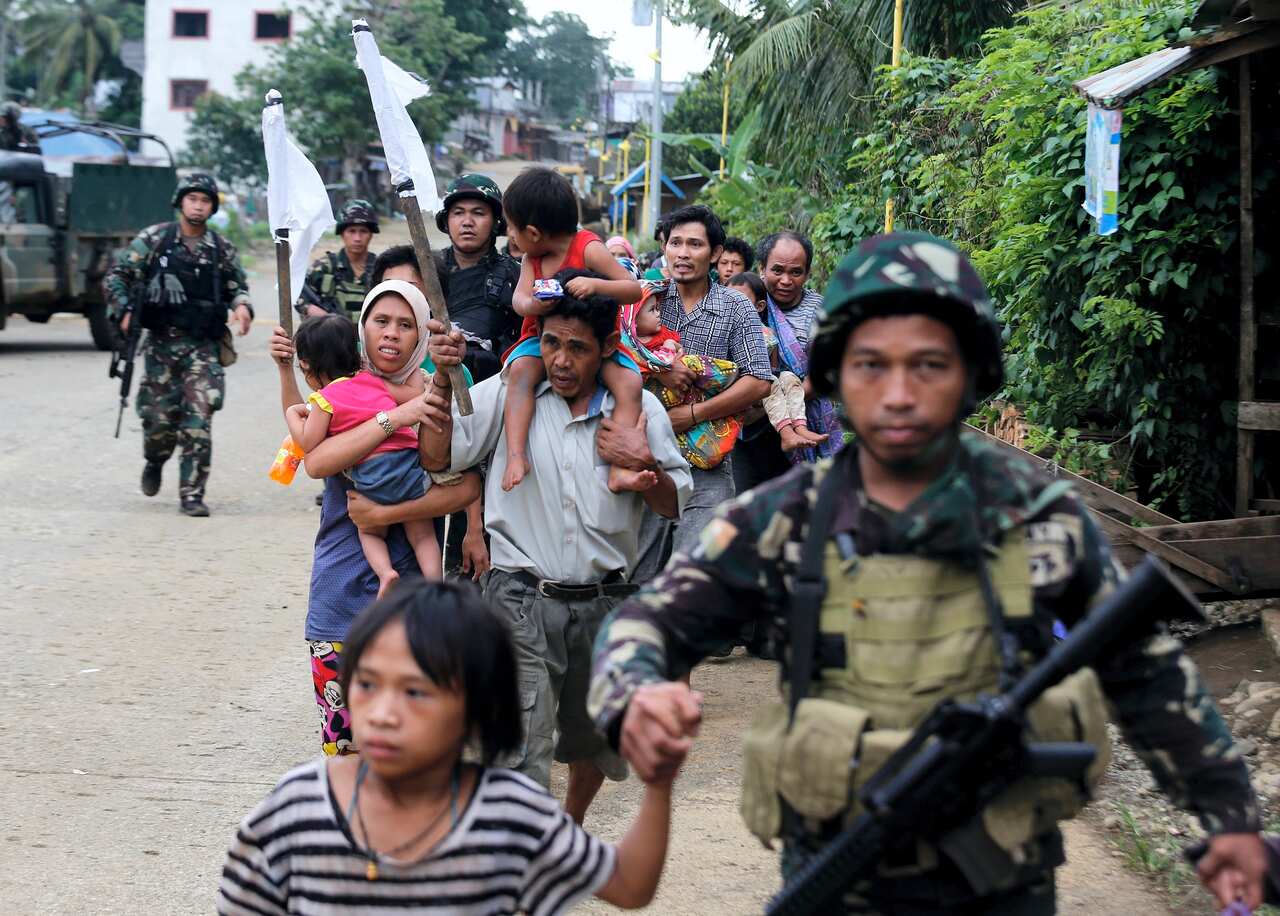 Trapped Filipino villagers are escorted by government troops during a rescue operation  in Marawi city, Mindanao island, southern Philippines, 31 May 2017.