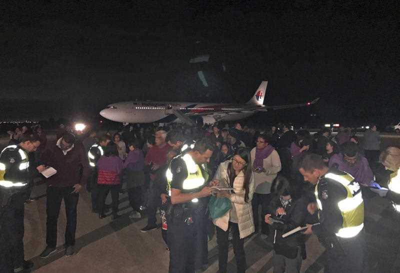Police take statements for passengers evacuated from a Malaysia Airlines plane after a man tried to enter its cockpit in Melbourne, Australia, Thursday, June 1, 2017.