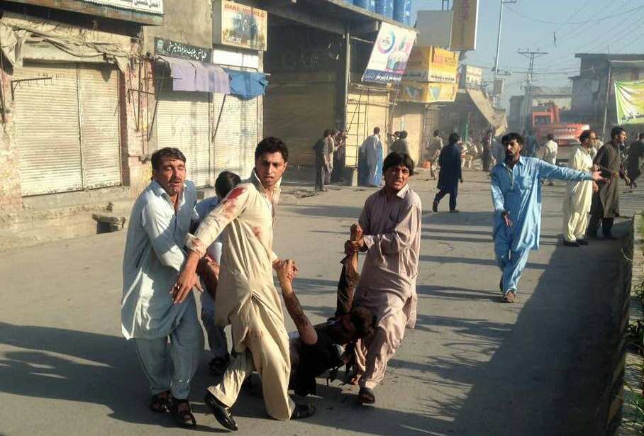 People carry a victim who was injured in a suicide bomb blast at Toori market in Parachinar, Pakistan