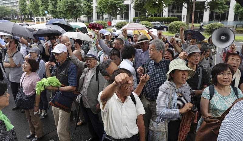 People gather in front of Tokyo District Court in Chiyoda Ward prior to the first trial on June 30