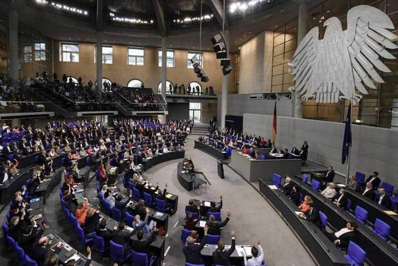 Members of Parliamentary Groups of the parties Die Linke (R), Social Democrats (C) and Greens (L) raise their hands to vote for a change of the order of the day at the German Parliament in Berlin, Germany, 30 June 2017.