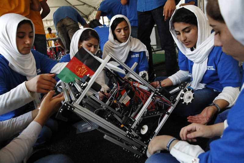 embers of the Afghanistan team make a repair to their robot after their first round competing in the FIRST Global Robotics Challenge