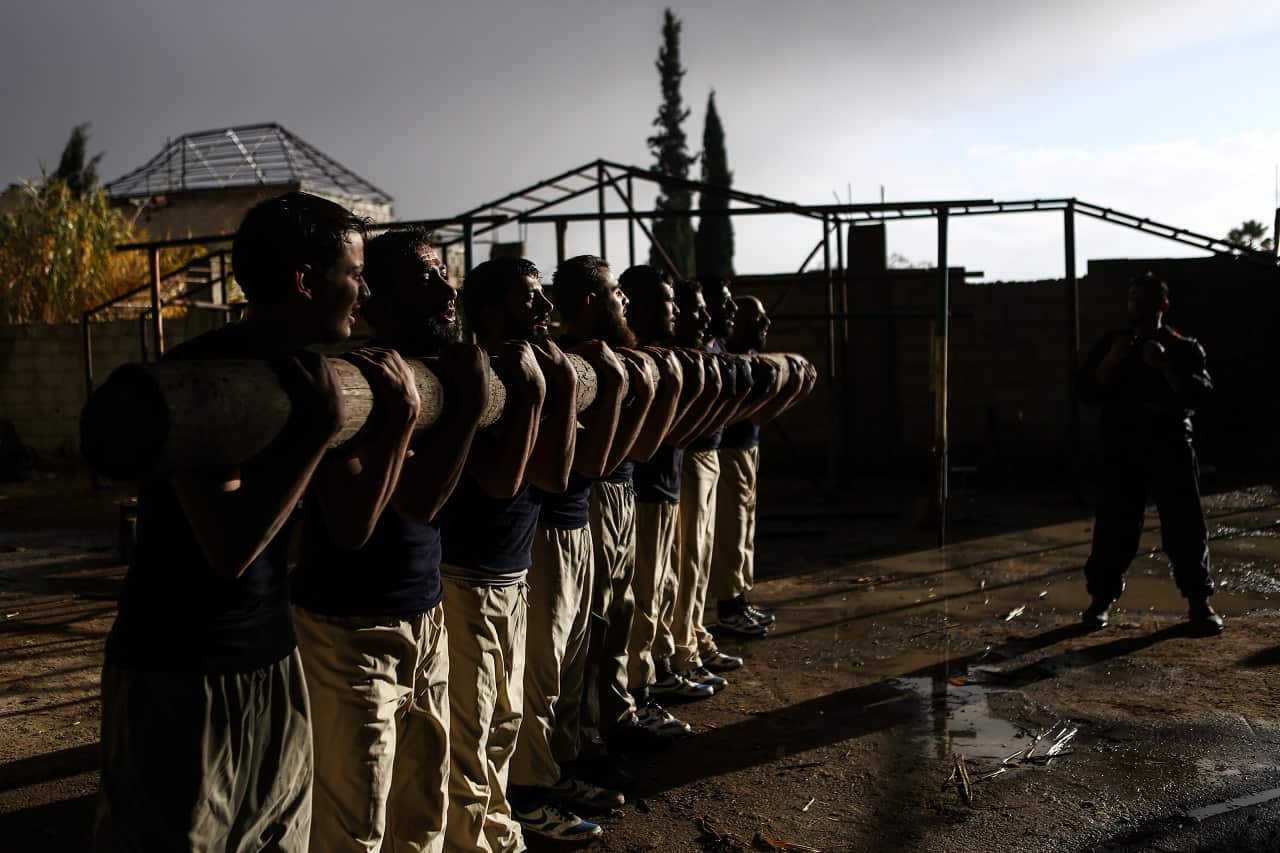 Cadets carry a wood log as part of their fitness training in Jaysh al-Islam Military Academy, in an undisclosed location, rebel-held Eastern Ghouta.