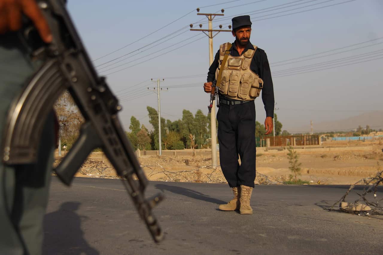 Afghan Police stand guard on a highway leading to Shah Wali Khan district, in Kandahar, Afghanistan