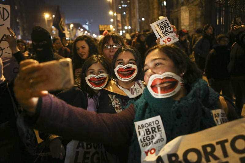 Girls pose for a photo during a march in favor of a bill backed by Chile's President Michelle Bachelet, to legalize abortions in three situations: