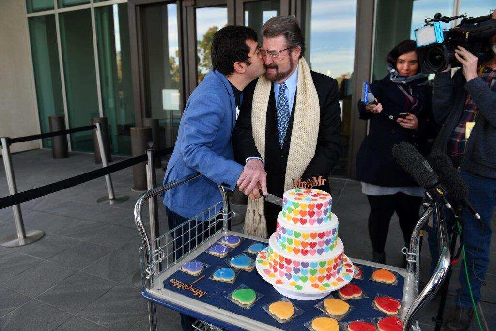 : Labor Senator Sam Dastyari kisses Derryn Hinch's Justice Party Senator Derryn Hinch after cutting a Marriage Equality Cake at the Senate doors at Parliament House in Canberra, Thursday, August 10, 2017