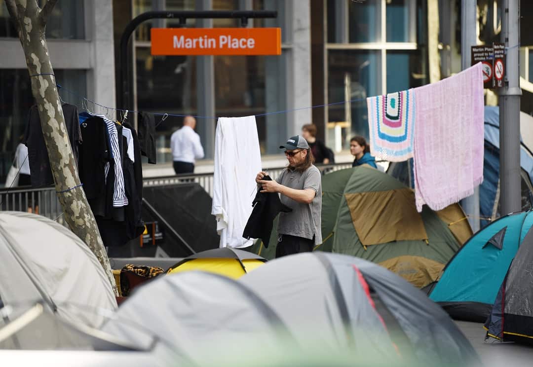 One of the residents of tent city hangs out his washing.