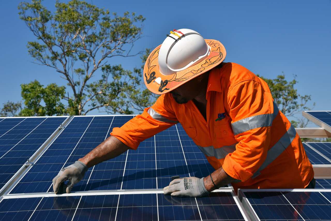 Workers install solar panels at a plant in the Nothern Territory. (AAP Image/Lucy Hughes Jones) 