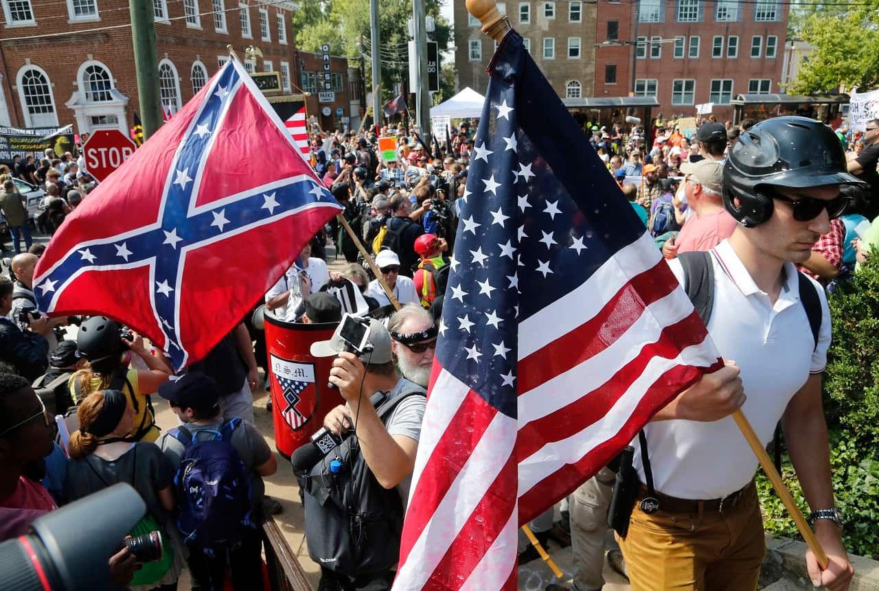 Alt Right demonstrators walk into Lee park surrounded by counter demonstrators in Charlottesville, Virginia.