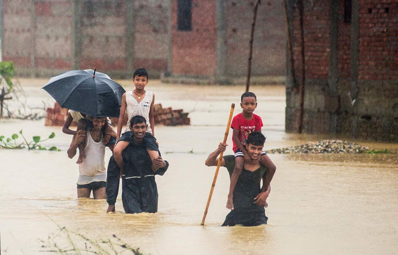 Nepalese villagers wade through flood waters in village Ramgadhwa in Birgunj, Nepal, Sunday, Aug. 13, 2017. 