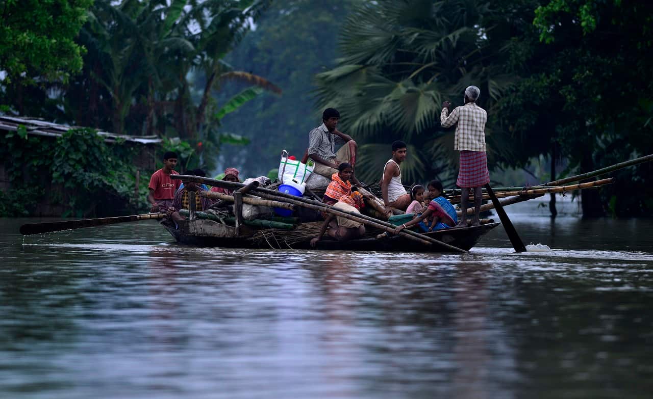 Indian villagers with their belongings shift to a relief camp from their flood affected village in Morigaon district, Assam state, India 13 August 2017.  