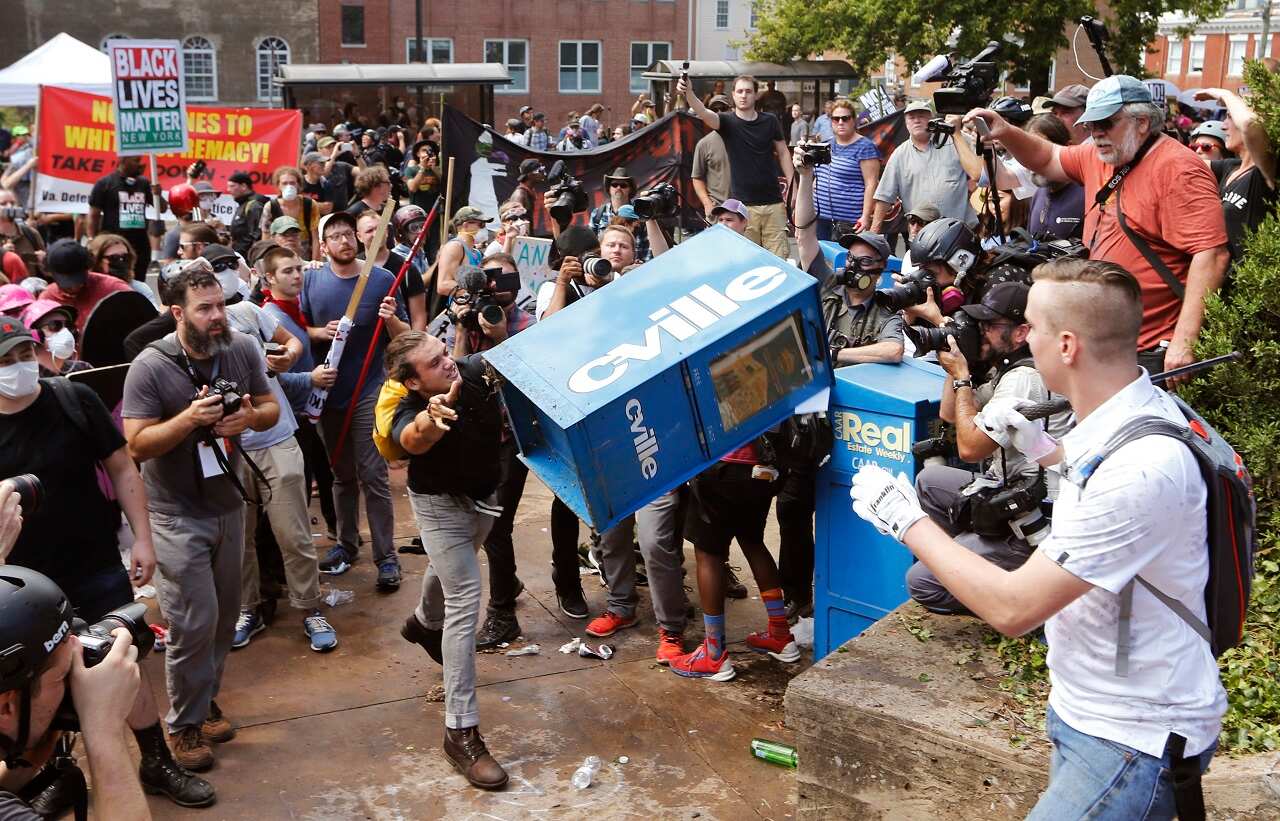 White nationalist demonstrators clash with a counter demonstrator at the entrance to Lee Park in Charlottesville, Va., Saturday, Aug. 12, 2017.