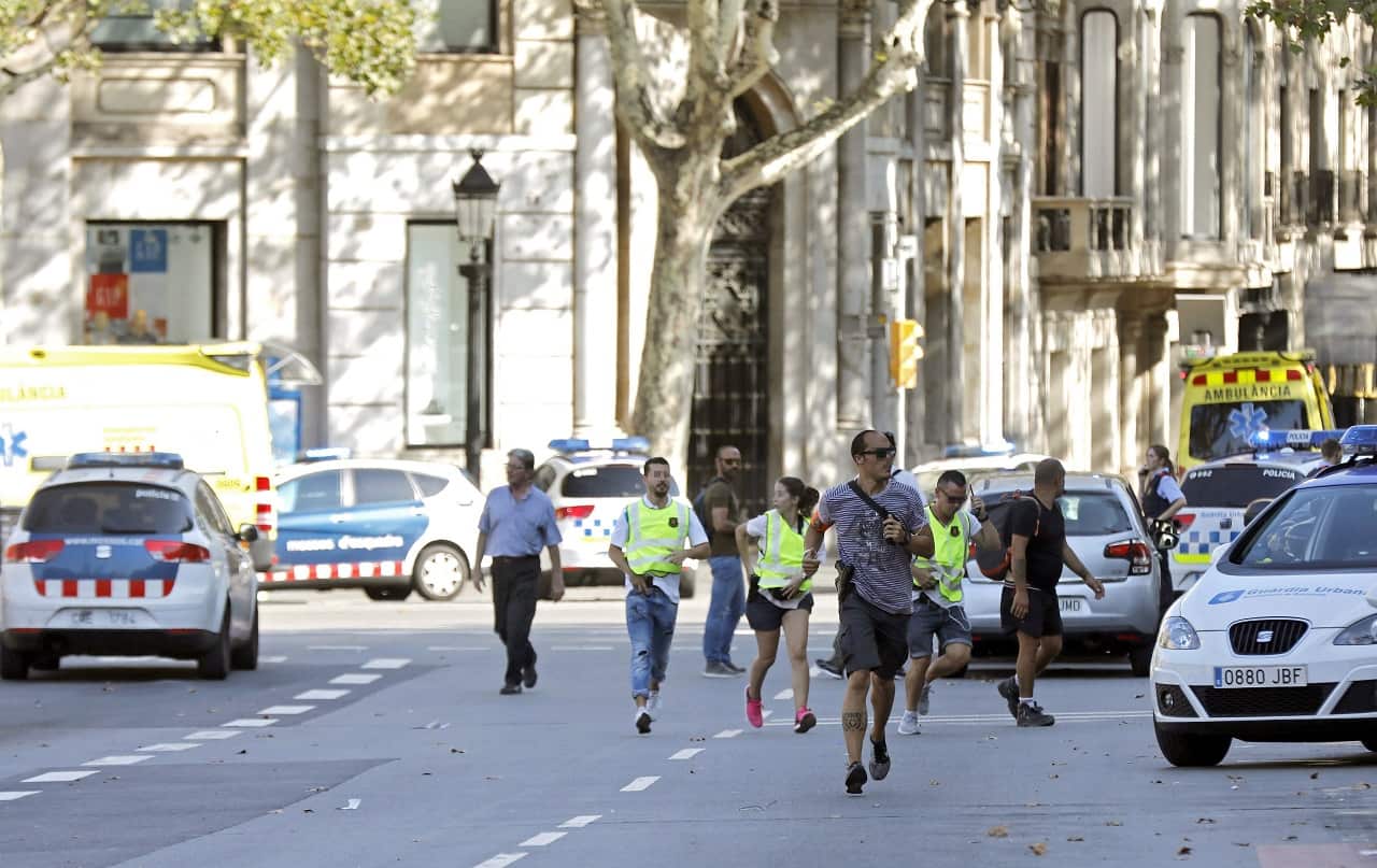 Mossos d'Esquadra Police officers and emergency service workers near the site where a van crashes into pedestrians in Las Ramblas, downtown Barcelona,