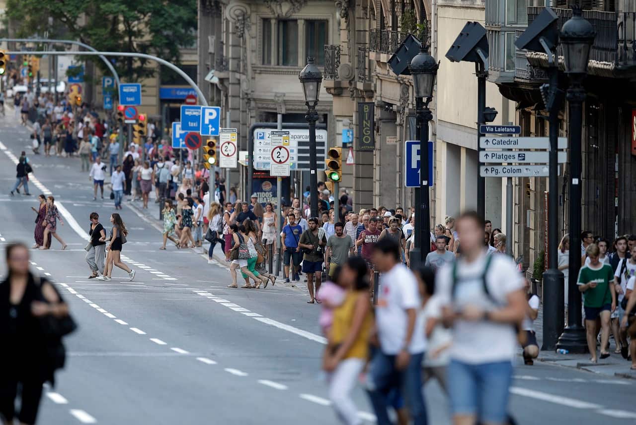 People walk down a main street in Barcelona, Spain, after the attack.