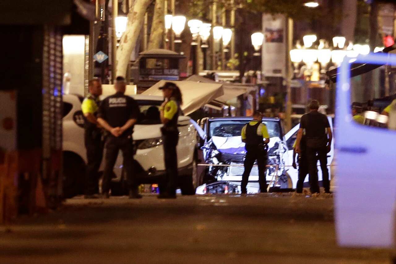 Police officers stand next to the van involved on an attack in Las Ramblas in Barcelona, Spain, Thursday.