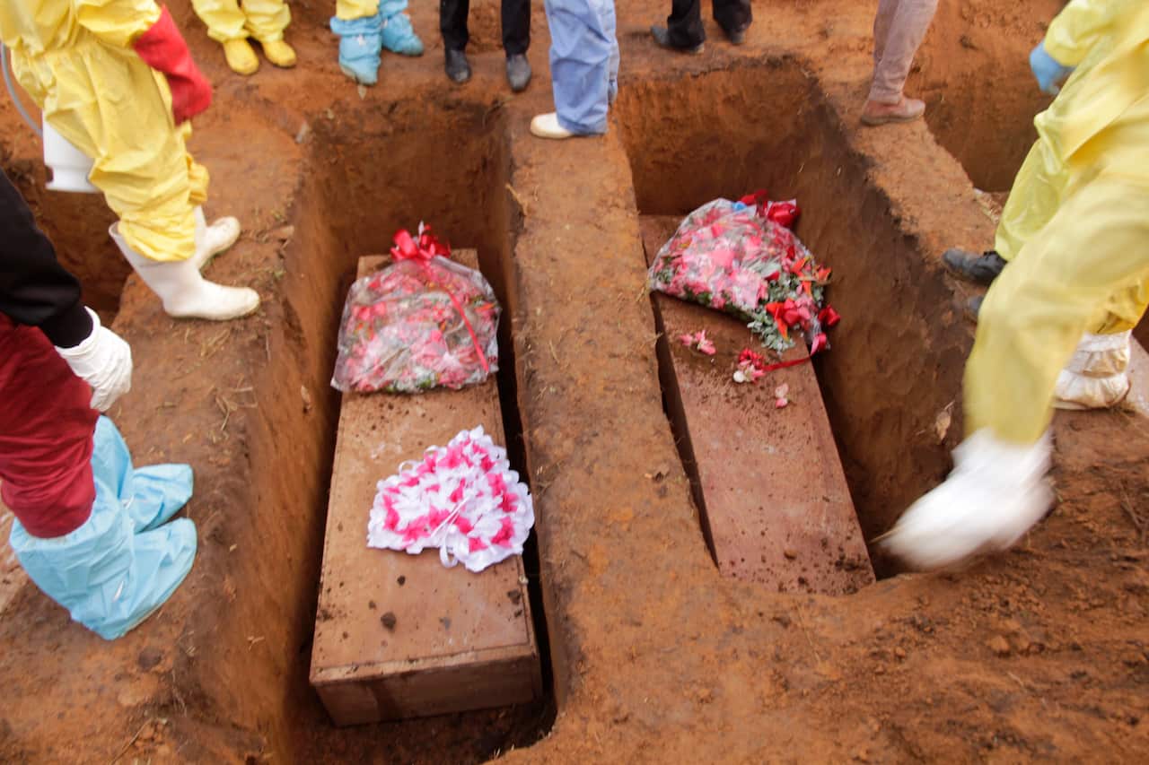 Volunteers bury coffins during a mass funeral for victims of heavy flooding and mudslides in Regent at a cemetery in Sierra Leone, Freetown.