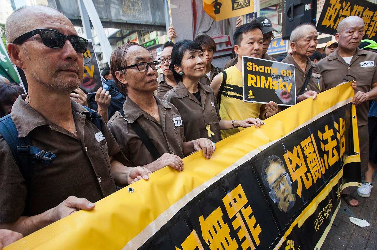 People march through the streets wearing prison uniforms as a statement in support of imprisoned student political activists.