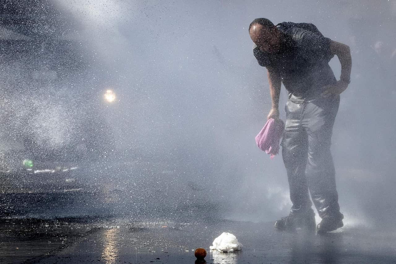  Italian law enforcement officers use water cannons to disperse about a hundred migrants protesting 