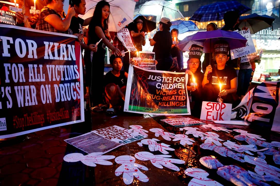 Protesters display placards and light candles during a rally to denounce the killing by police of Kian Loyd delos Santos (AP Photo/Bullit Marquez).