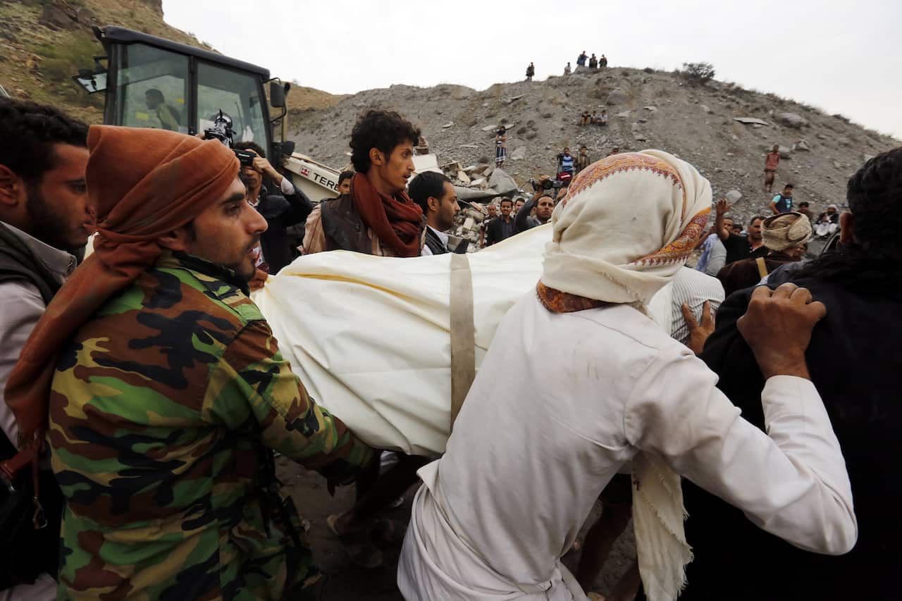 Yemenis carry the body of a man recovered from a building allegedly hit by a Saudi-led airstrike in Sanaa.