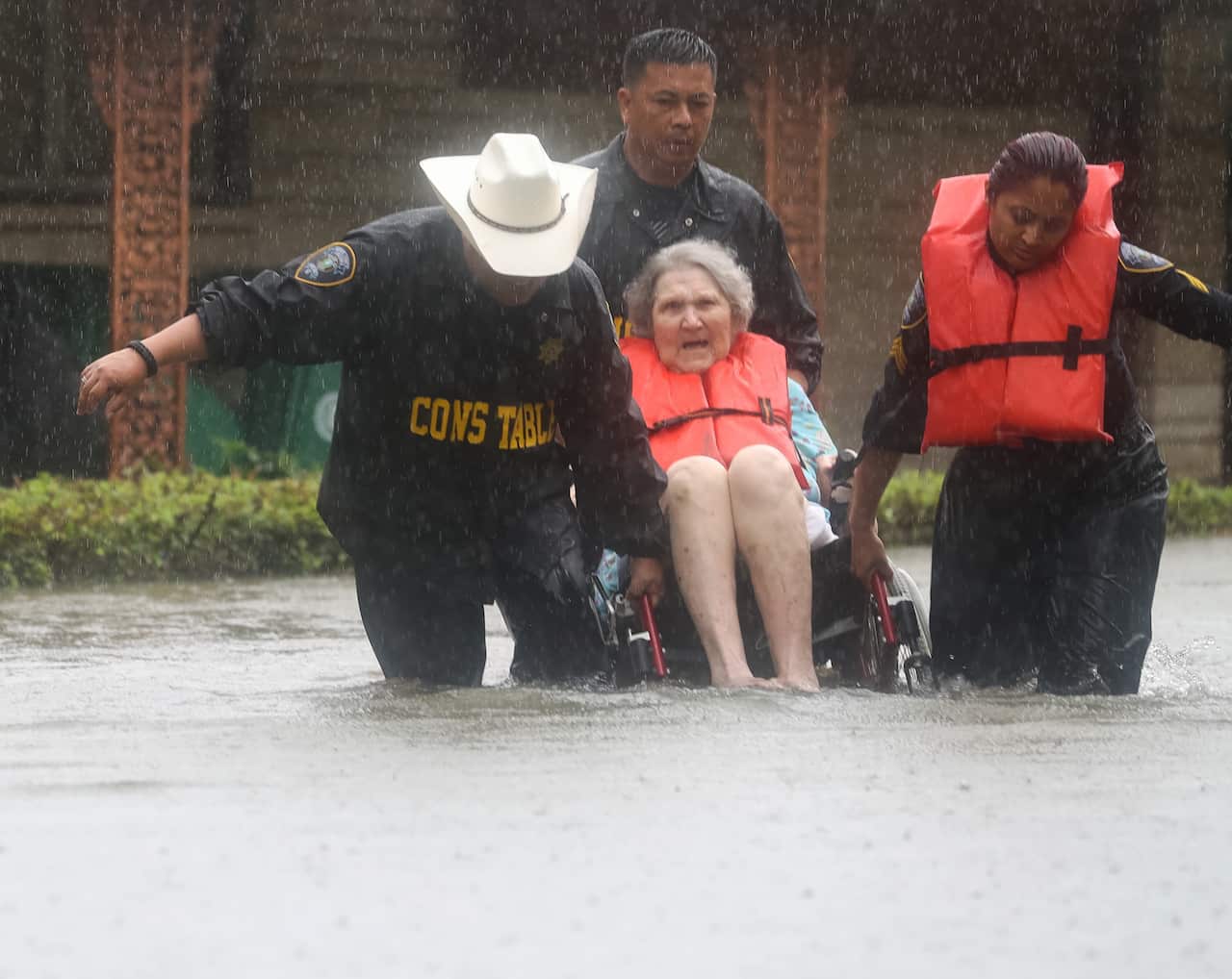 An elderly woman is rescued from rising waters