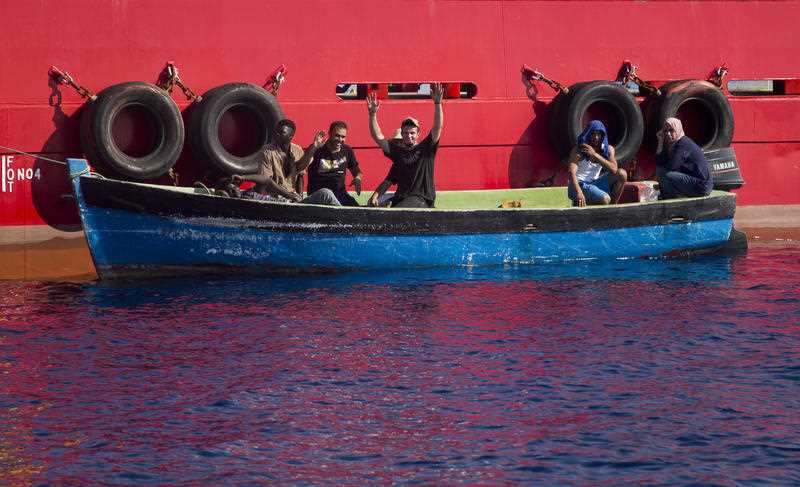 Moored alongside a supply ship for oil rigs, migrants wave to rescuers from the Aquarius vessel of SOS Mediterranee NGO and MSF (Doctors Without Borders), in the Mediterranean Sea north of Libyan coast.