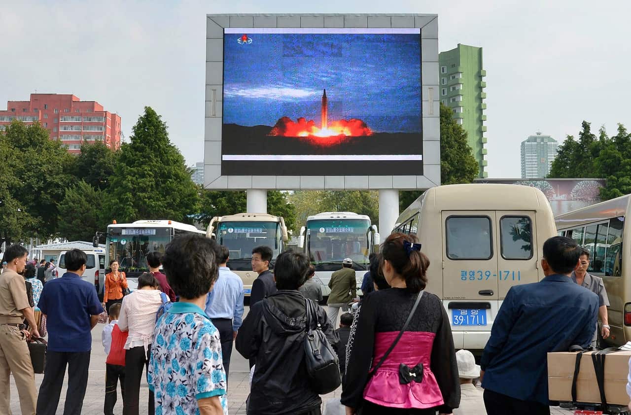 North Koreans watch news of their country's latest ballistic missile launch on a big screen in front of Pyongyang Station in the capital on Aug. 30, 2017.