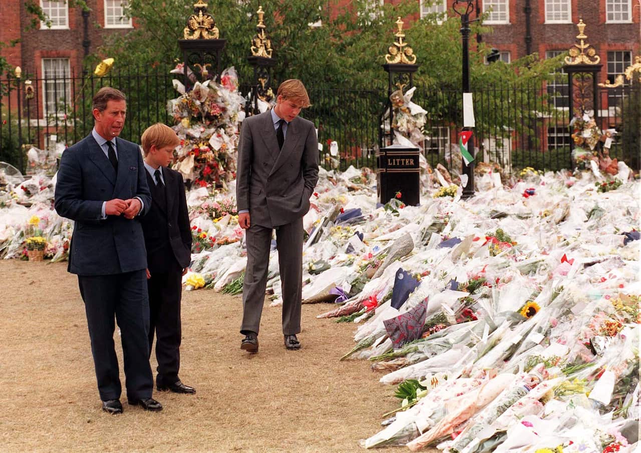 File photo dated 5/9/1997 of the Prince of Wales and his sons Prince William (right) and Prince Harry, view the sea of floral tributes to Diana