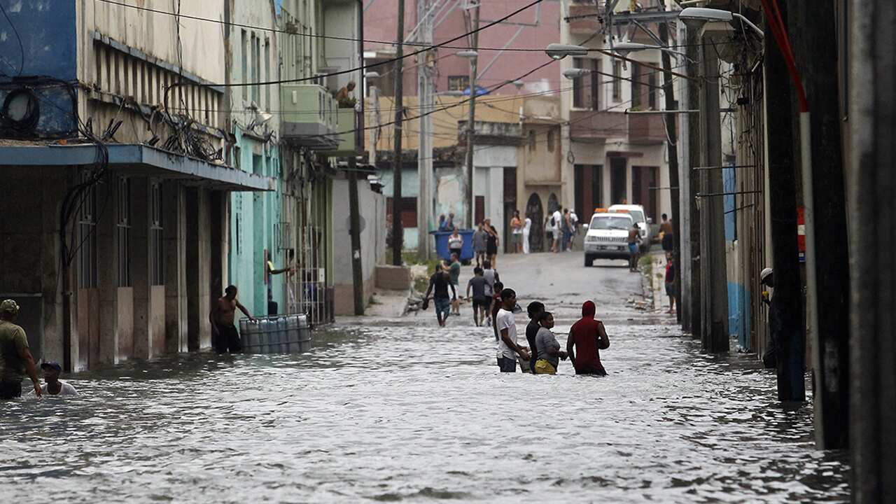 People walk in the water at a flooded street