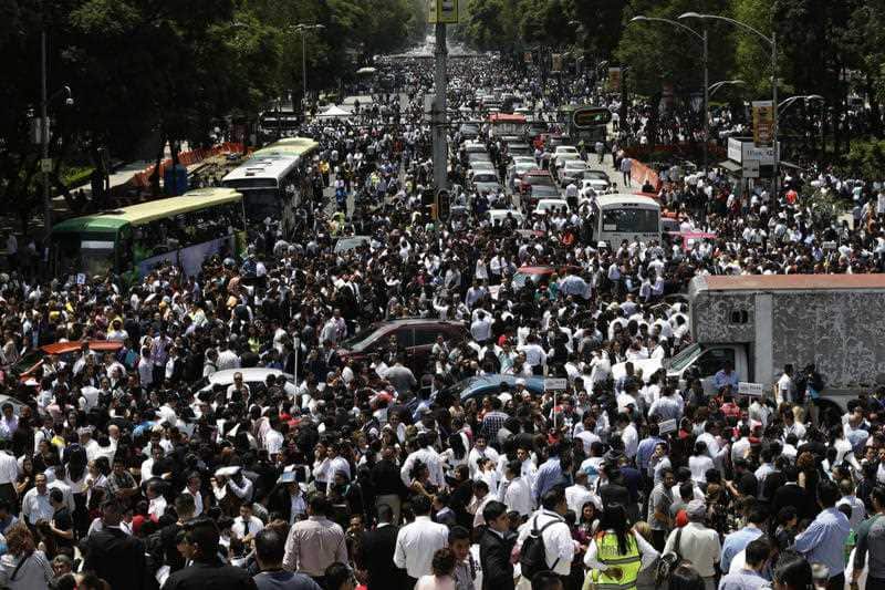 People evacuated from office buildings gather in Reforma Avenue after an earthquake in Mexico City, Tuesday Sept. 19, 2017.