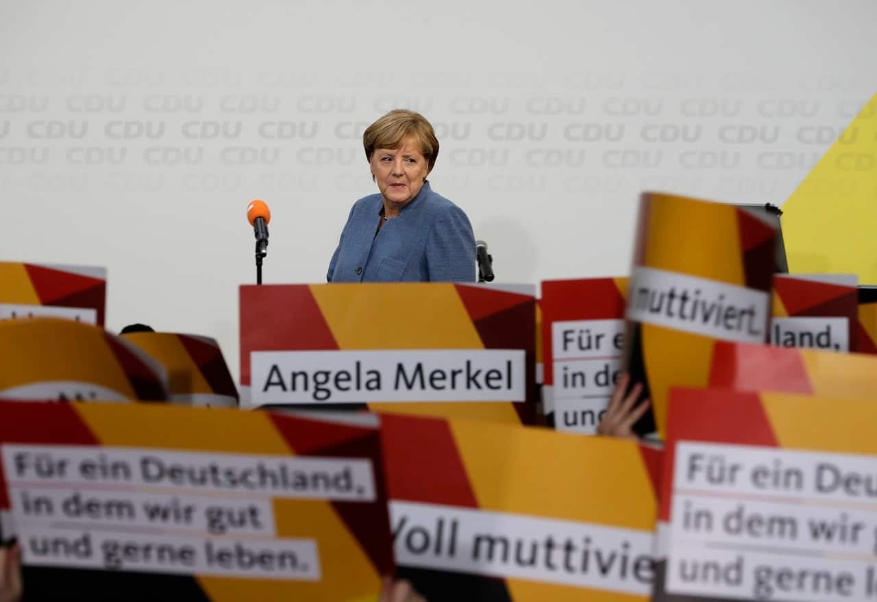 Supporters hold posters as German Chancellor Angela Merkel returns on the stage at the headquarters of the Christian Democratic Union CDU in Berlin.