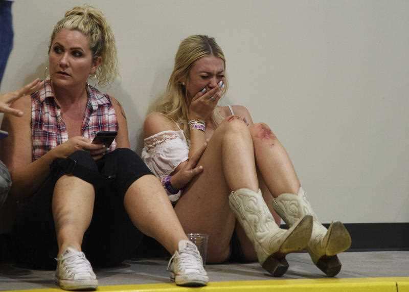 A woman cries while hiding inside the Sands Corporation plane hangar after a mass shooting in which dozens were killed at the Route 91 Harvest country festival on Sunday, Oct. 1, 2017, in Las Vegas.