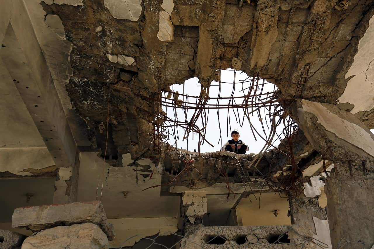 A Yemeni child looks through a hole in the ceiling of a severely damaged house that reportedly was destroyed by Saudi-led airstrikes.