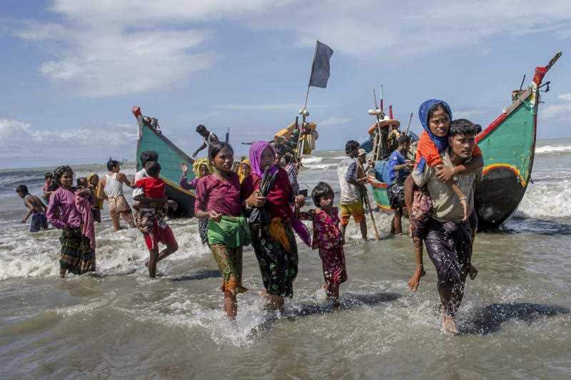 Rohingya Muslims walk towards shore after arriving on a boat from Myanmar to Bangladesh in Shah Porir Dwip, Bangladesh on Sept. 14, 2017.