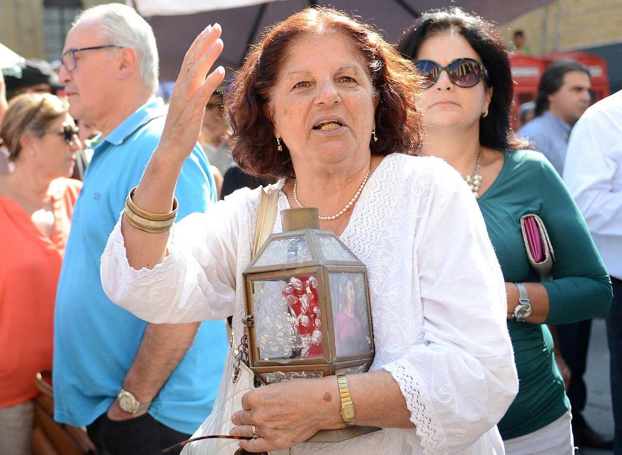 A lady holds a candle and photo of the victim, as she says justice will never be served.