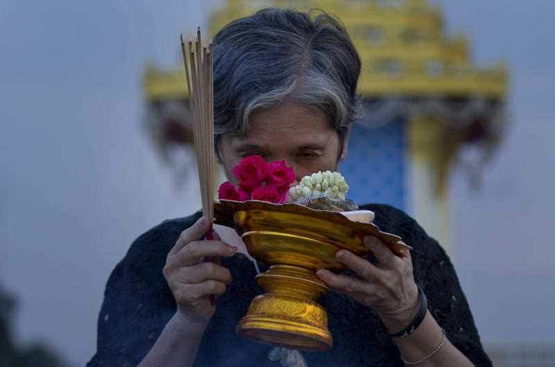A Thai mourner prays in front of a replica of the royal crematorium in Bangkok, Thailand, Wednesday, Oct. 25, 2017.