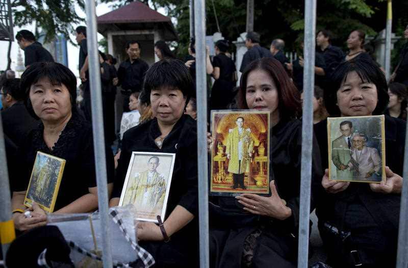 Thai mourners in black attire gather close to a replica of the royal crematorium in Bangkok, Thailand, Thursday, Oct. 26, 2017.