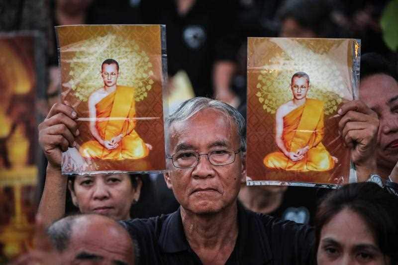 A Thai mourner holds a picture of the late Thai King Bhumibol Adulyadej as he waits for the royal cremation ceremony outside the Royal Palace in Bangkok, Thailand, 26 October 2017.