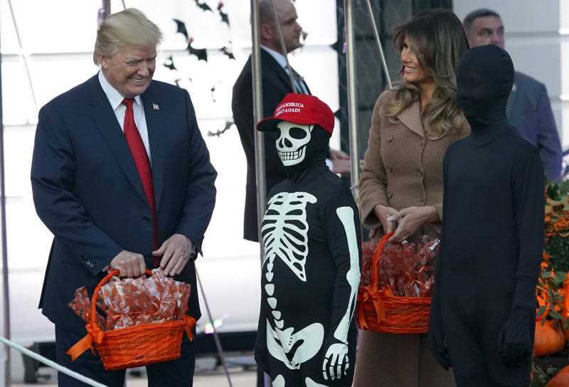 The Trumps hand out treats as they welcome children from the Washington area.