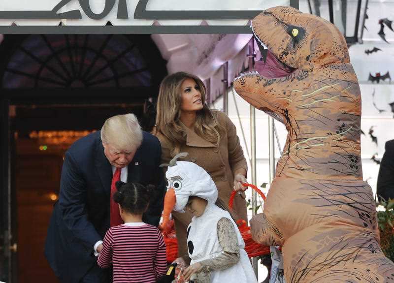 President Donald Trump and first lady Melania Trump hand out treats as they welcome children from the Washington area and children of military families to trick-or-treat celebrating Halloween at the South Lawn of the White House in Washington, Monday.