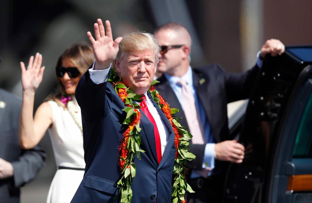 Donald Trump walks towards the motorcade with first lady Melania Trump to meet servicemen in Honolulu.