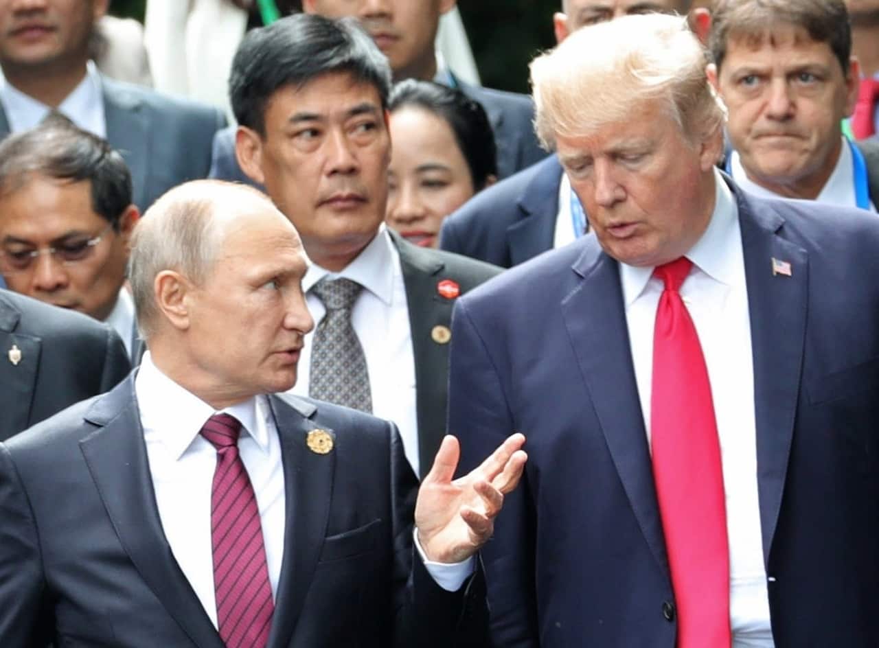 Donald Trump and Vladimir Putin talk during a photo session at the APEC summit in Vietnam.