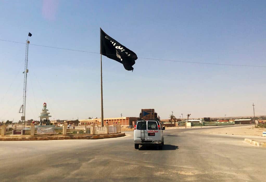 A motorist passing by a flag of the IS group in central Rawa in July 2014.