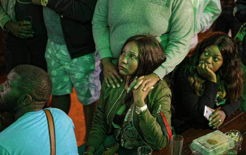 Disappointed Zimbabweans watch a televised address to the nation by President Robert Mugabe at a bar in downtown Harare, Zimbabwe Sunday, Nov. 19, 2017.
