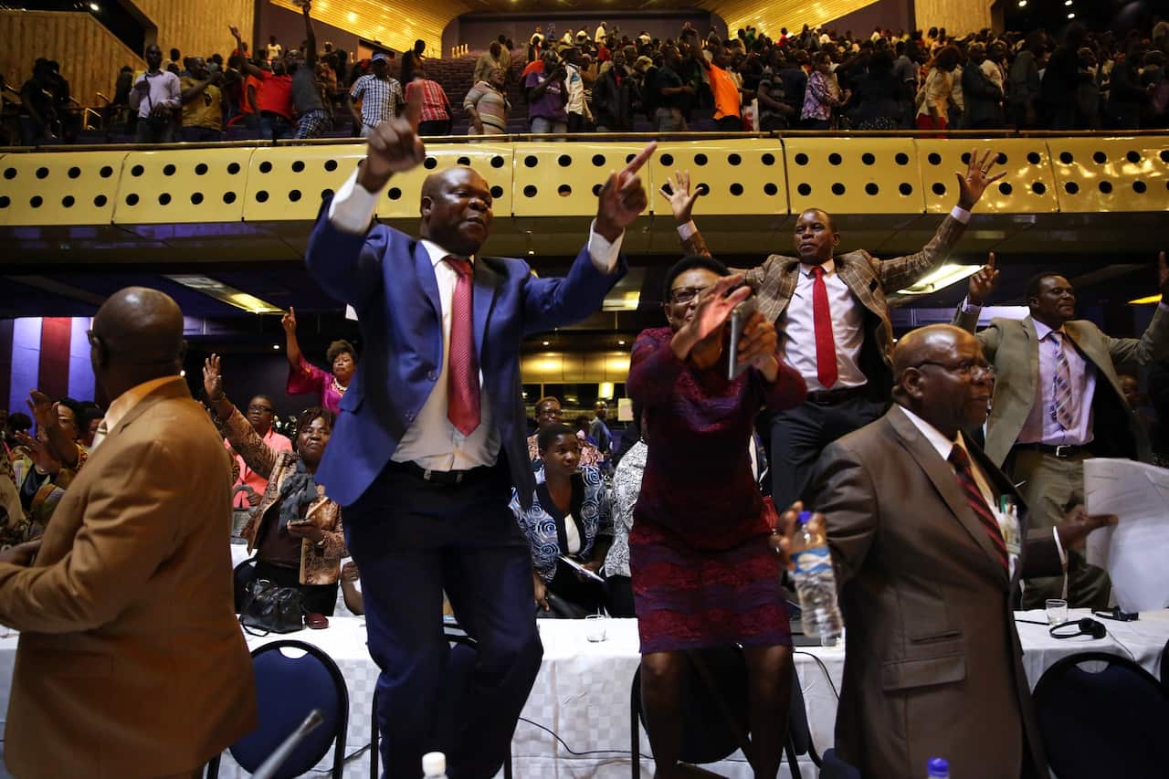 People react after the speaker of the House of Assembly Jacob Mudenda read a letter sent to him by Zimbabwean President Robert Mugabe on his resignation at the Harare International Conference Centre in Harare, Zimbabwe, 21 November 2017.