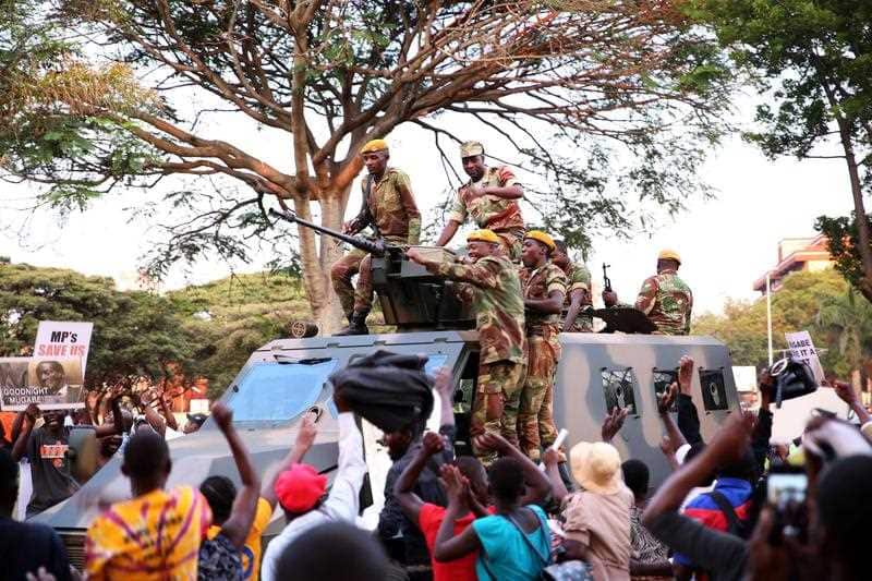 People celebrate after hearing the news that President Robert Mugabe resigned in Harare, Zimbabwe, 21 November 2017.