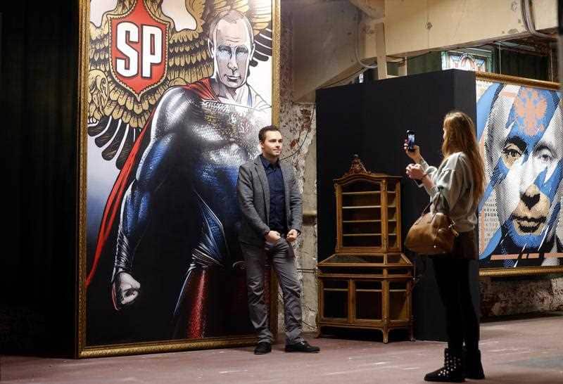 Visitors in front of an artwork depicting Russian President Vladimir Putin during the SUPERPUTIN exhibition at the Ultra Modern Art Museum (UMAM) in Moscow, Russia, 07 December 2017.