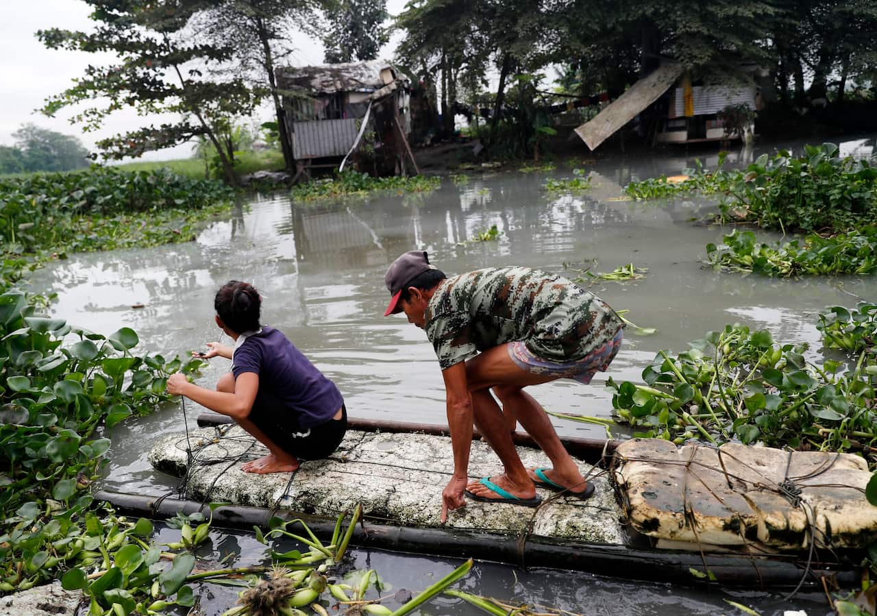 Filipinos on a makeshift raft wade through floodwater in Taguig city, south of Manila.