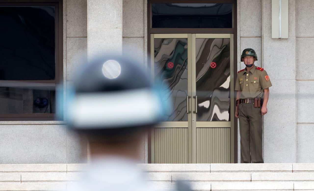 A South Korean soldier looks at a North Korean soldier at Panmunjom.